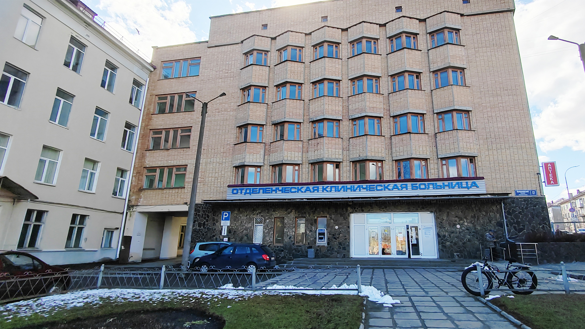 Пятиэтажное административное здание больницы с мощёной площадкой перед крыльцом.