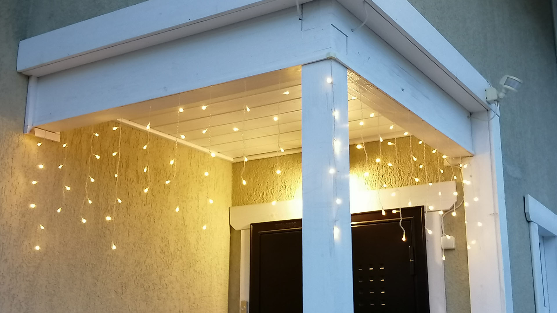 Светодиодная гирлянда на крыльце дома в режиме постоянного свечения.
