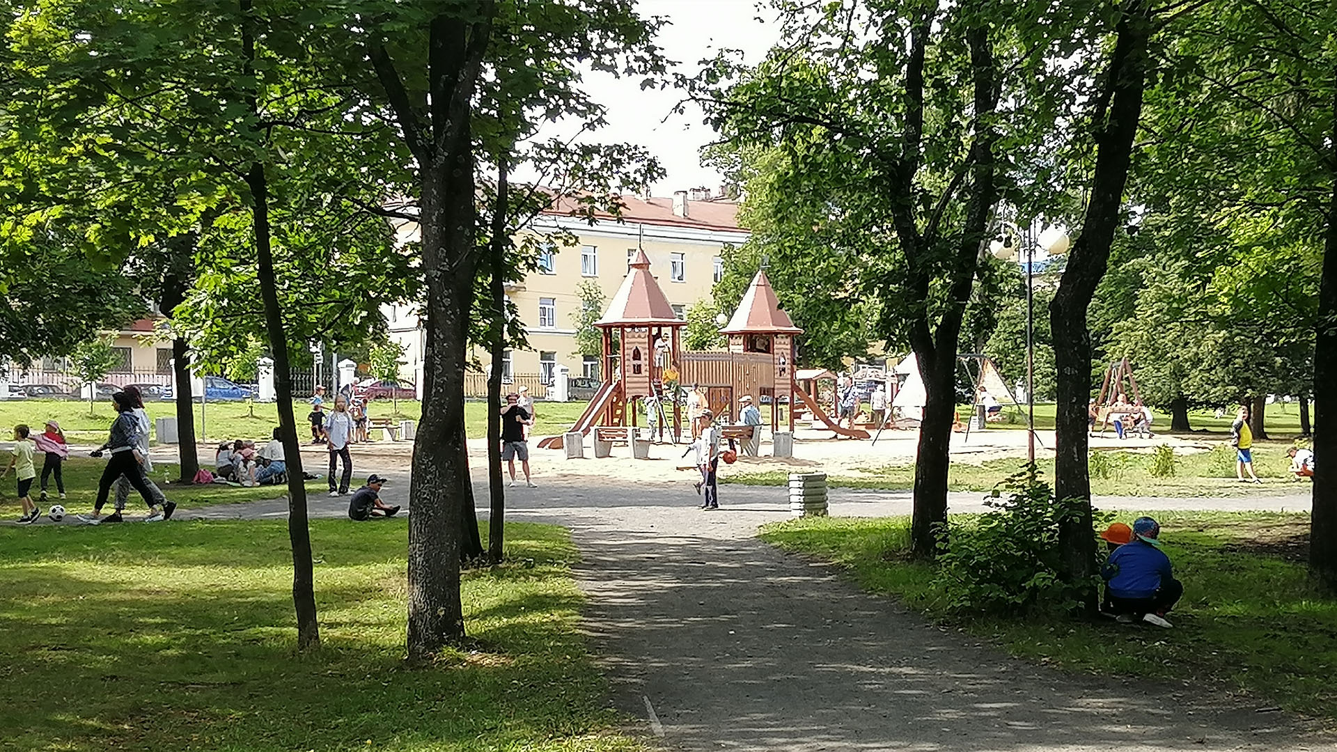 Детская площадка окружённая высокими деревьями
