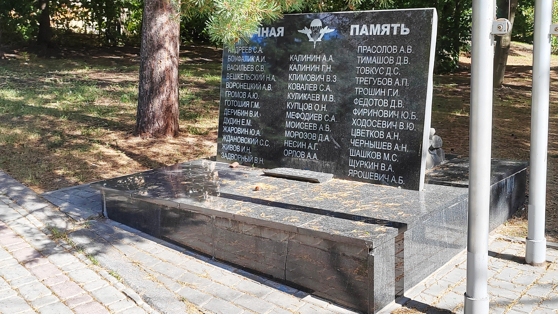 Памятная табличка с именами павших героев Мемориальная плита из тёмного камня с высеченными на ней именами героев.